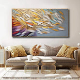 Modern living room with beige sofa, colorful abstract wall art, and gold accent tables