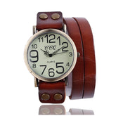 Vintage-style quartz watch with large dial, brown leather wrap strap, and metal rivets.