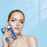 Woman holding colorful graphic face mask packet, bare shoulders, natural makeup, blue background