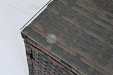 Close-up of dark brown wicker outdoor table with glass top and protective pad