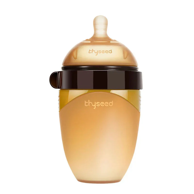 Translucent amber silicone baby bottle with wide neck and soft nipple, brown lid