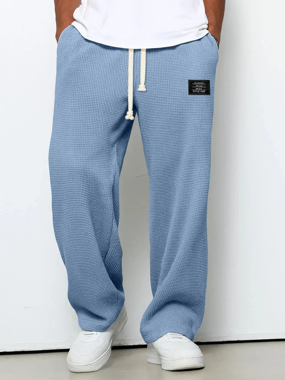 Light blue waffle knit jogger pants with relaxed fit, cream drawstring, casual streetwear style