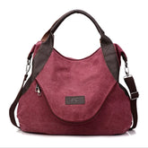 Burgundy canvas shoulder bag with brown faux leather accents and adjustable strap