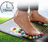 Bare feet on colorful acupressure mat outdoors, black slim-fit pants, relaxed fit