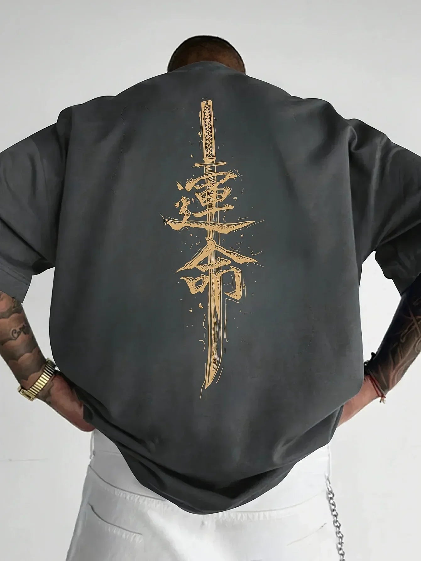 Oversized black streetwear t-shirt with bold gold sword and Asian script graphic on back