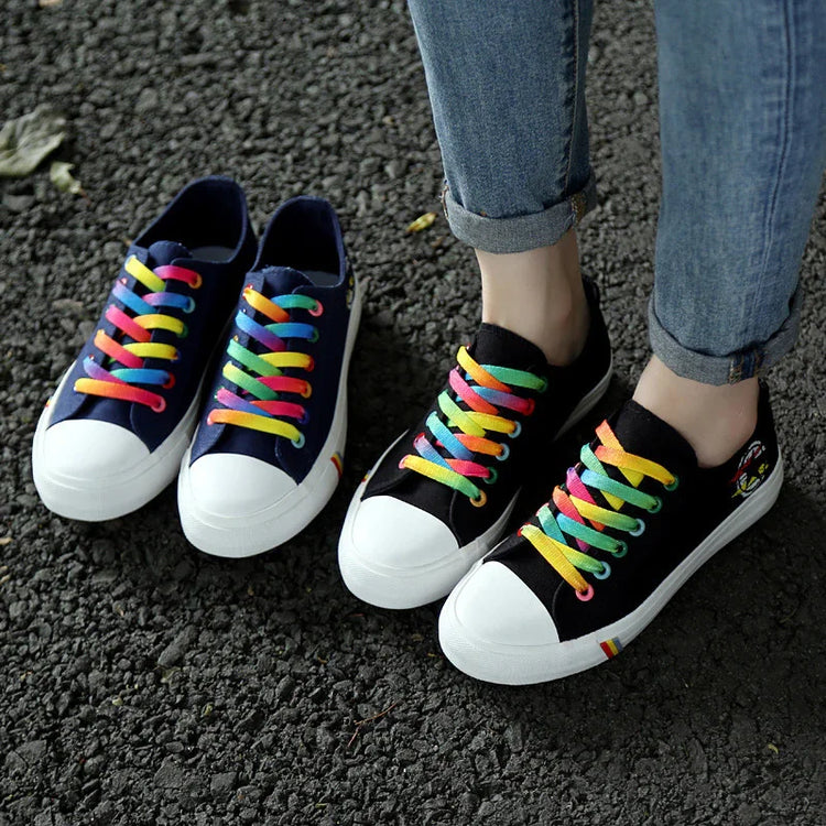 Canvas sneakers with rainbow laces, white toe caps, paired with rolled denim jeans