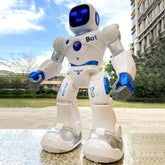 White and blue plastic robot toy with LED face, standing outdoors on pavement