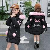 Girl wearing black puffer coat with pink faux fur trim, heart patches, and loose fit