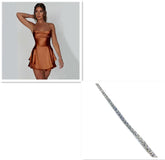 Woman wearing a copper satin mini dress with spaghetti straps and ruffled hem, next to a silver tennis bracelet.