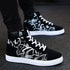 Black and white high-top sneakers with abstract graffiti design and white soles
