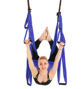 Woman in black fitted activewear using a blue aerial yoga hammock performing a stretch pose