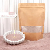 Milk tea color scented candle sand in kraft resealable bag and white dish, powder texture.