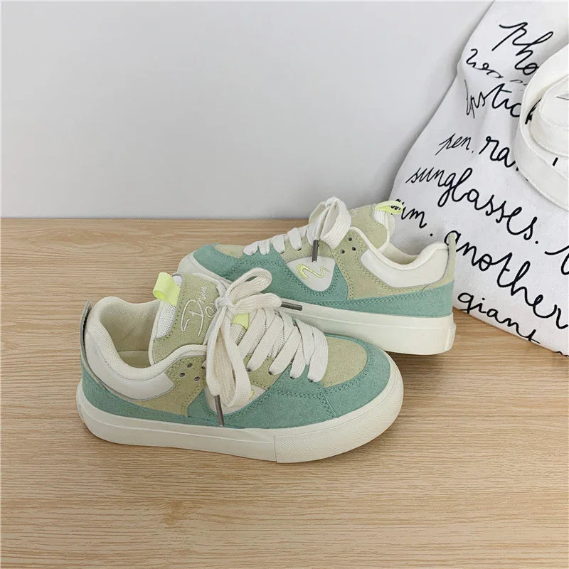 Pastel green and beige suede low-top sneakers with chunky soles and cream laces, casual fit