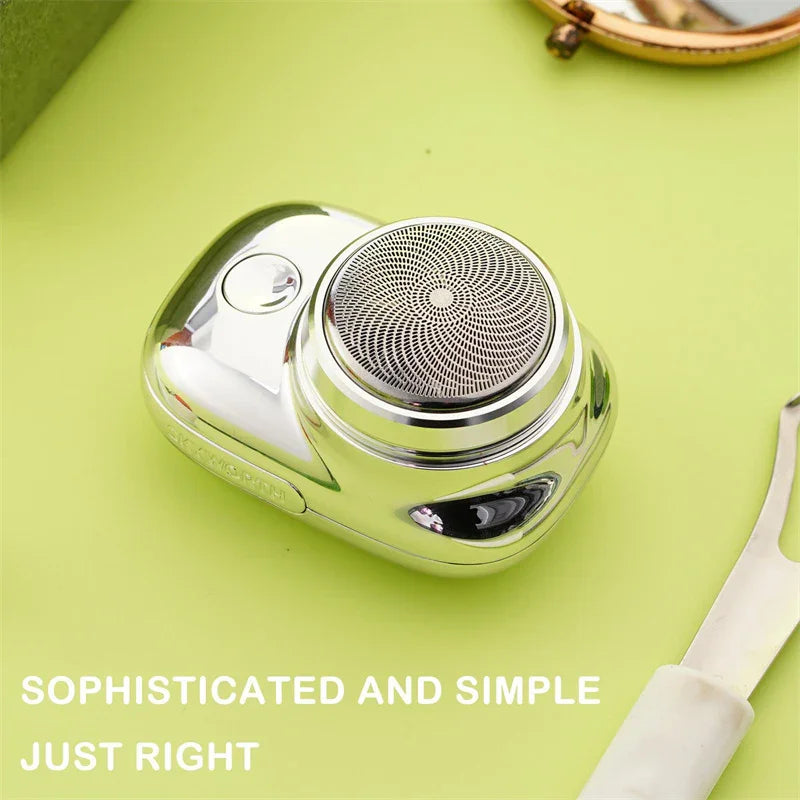 Compact silver electric shaver with circular foil head on light green background