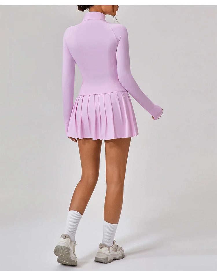 Light pink long sleeve pleated mini dress, fitted with high neck, shown from the back.