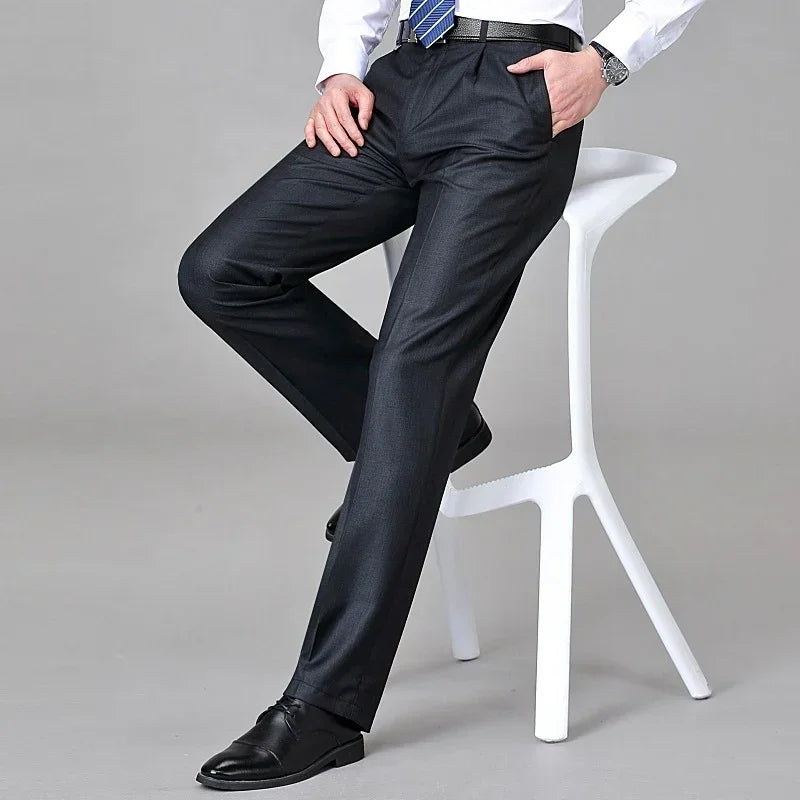 Men's slim-fit black dress pants, smooth fabric, paired with dress shoes in a modern setting.