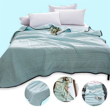 Light blue lightweight quilted blanket on bed with white pillows, soft fabric, relaxed fit
