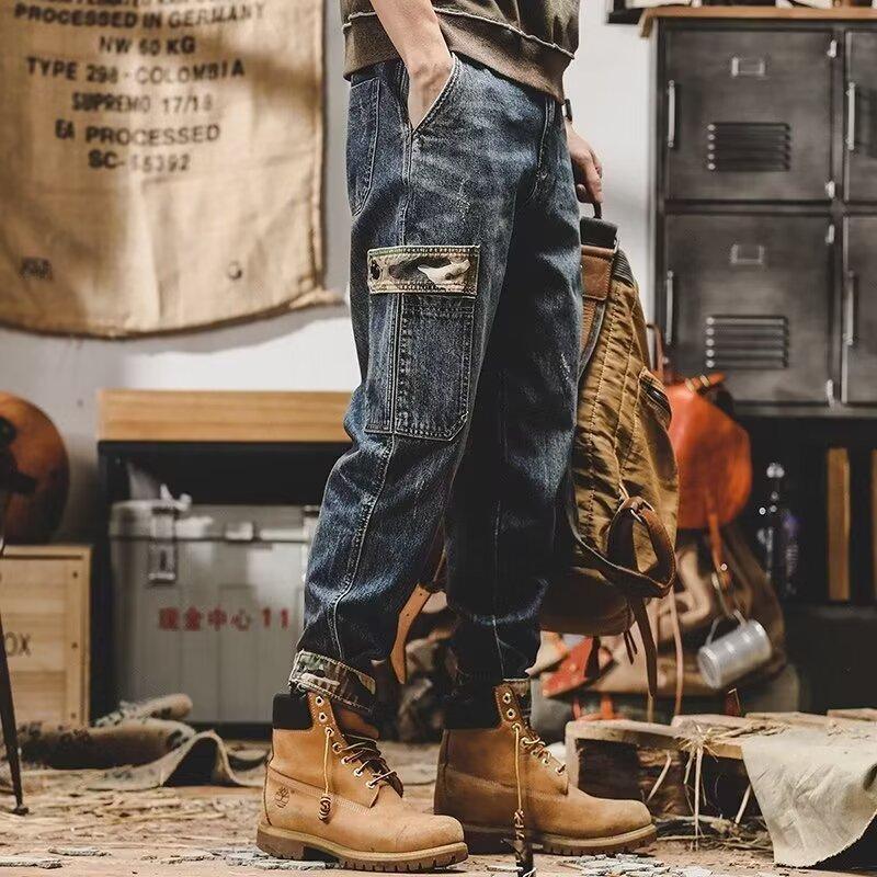 Relaxed fit blue denim cargo pants with camo pocket, paired with tan work boots