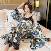 Woman in cream and black floral silk pajama set with lace trim, relaxed fit, sitting on bed