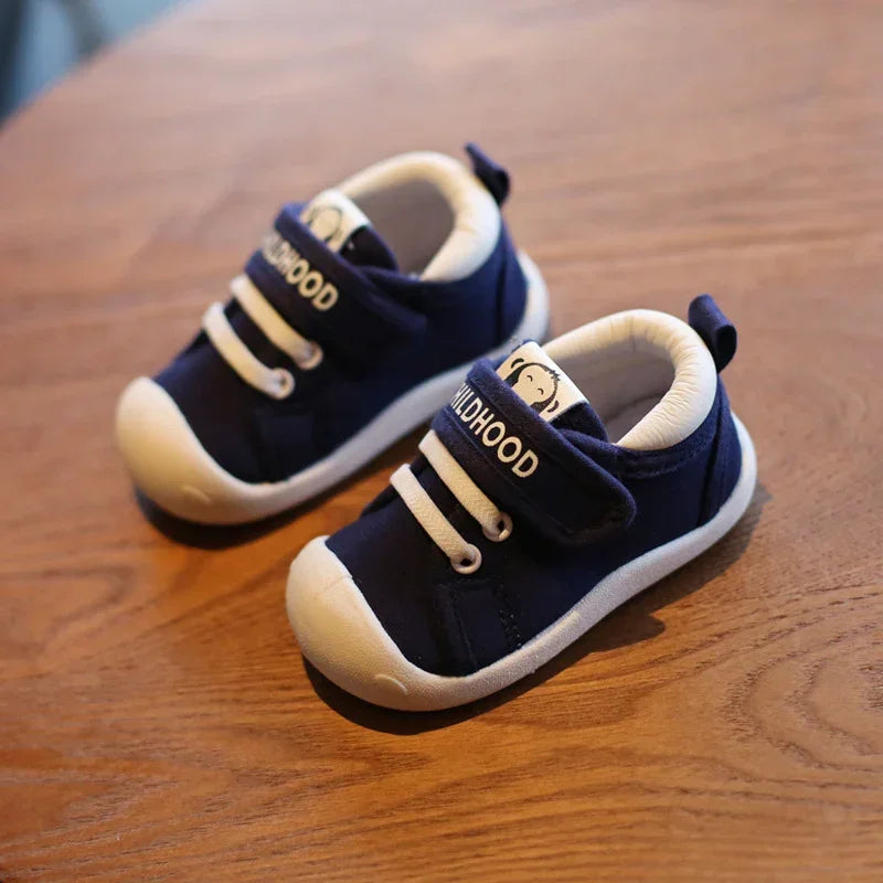 Navy blue toddler sneakers with white soles and laces, soft fabric, velcro strap fit