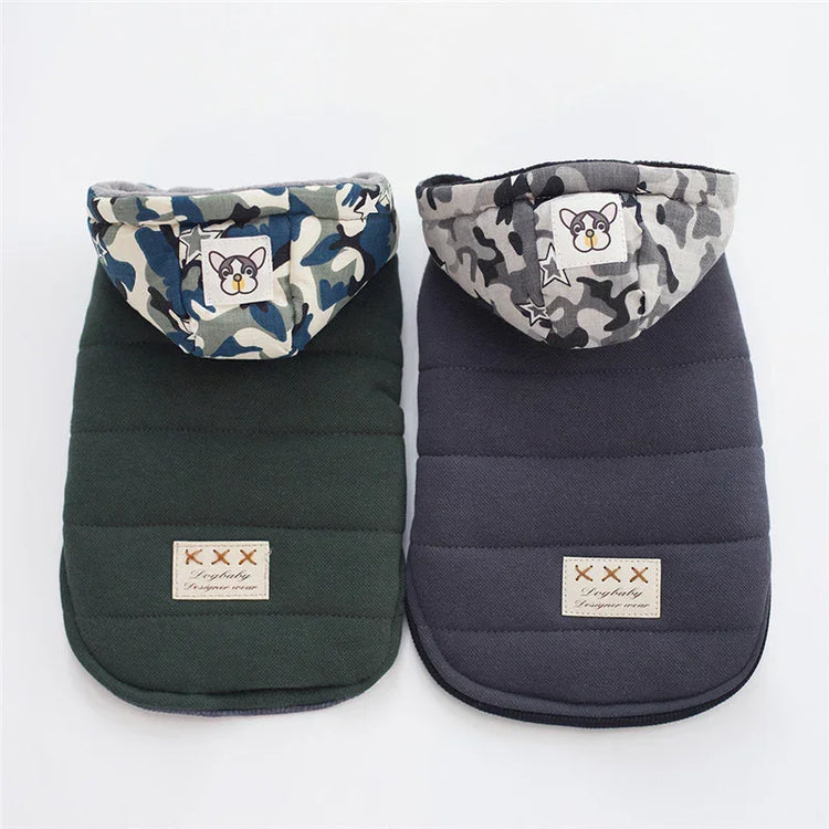Two padded pet jackets, one dark green and one navy, with camo hoods and cartoon patches.