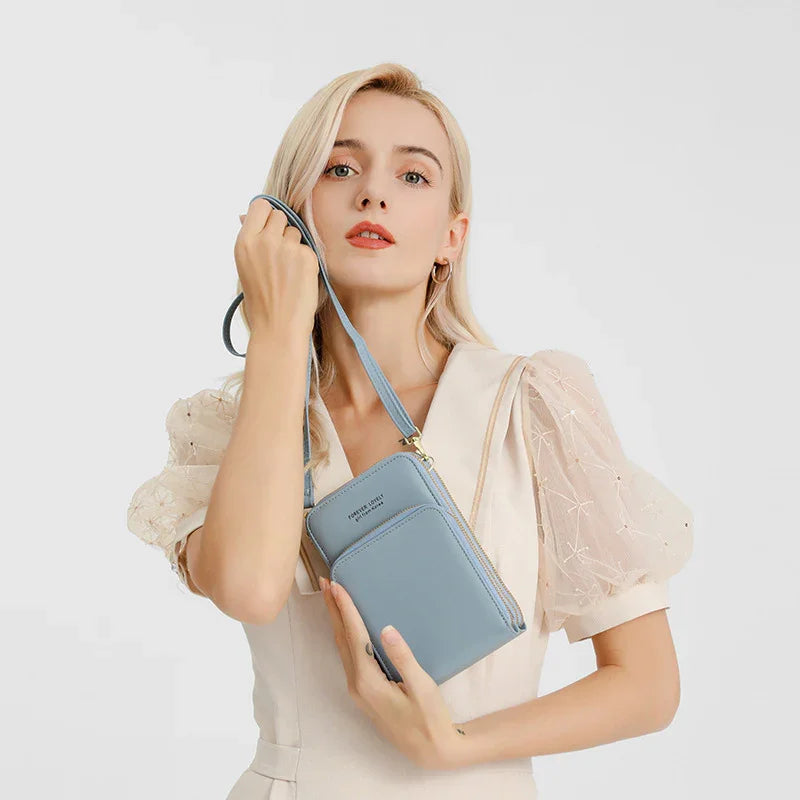 Woman in cream puff sleeve dress holding light blue faux leather crossbody bag