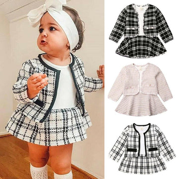 Baby girl in plaid tweed skirt set with jacket, long sleeves, matching headband, and knee socks
