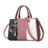 Color block handbag with pink, black, and white panels, textured faux leather, structured fit, top handles, and fluffy pom pom charm.