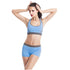 Woman in fitted blue athletic sports bra and shorts set, smooth stretch fabric, contrast waistband