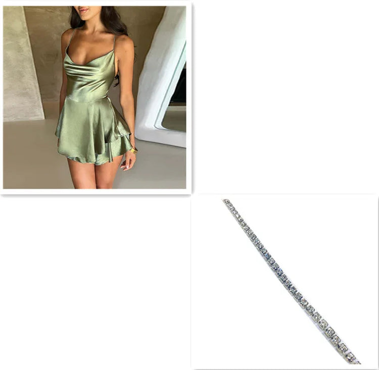 Woman wearing a satin green mini dress with a draped neckline, fitted waist, and flowy skirt