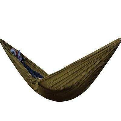 Person lying in an olive green, lightweight, fabric hammock with relaxed casual fit clothing