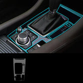 Close-up of car center console with black leather gear shift, illuminated blue trim, and metallic dials.