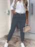 Woman in white button-up shirt and slim-fit gray jogger pants, casual streetwear style