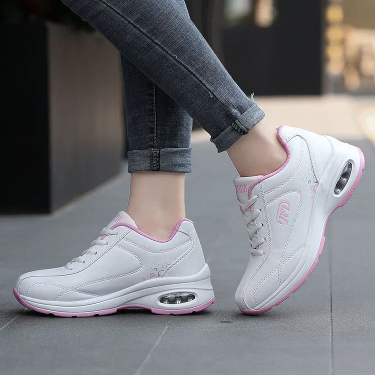 White and pink chunky sneakers with visible air sole, worn with slim ankle jeans, street style