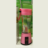 Pink portable blender with clear plastic body and carry strap, compact design.