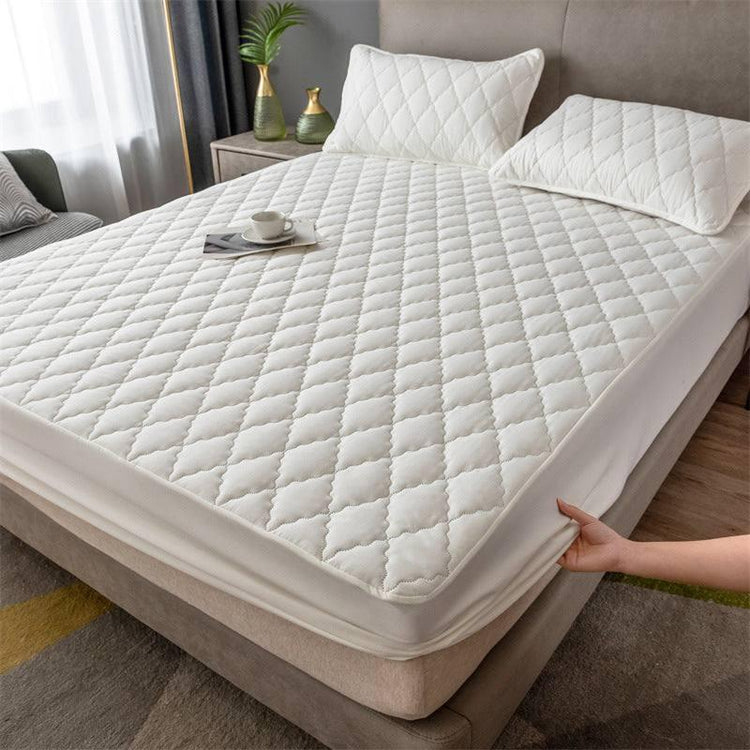 White quilted mattress cover with matching pillows, soft fabric, deep pocket fit on bed