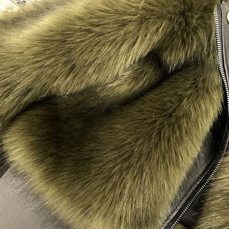 Close-up of olive green faux fur jacket with textured, plush material and a metal zipper
