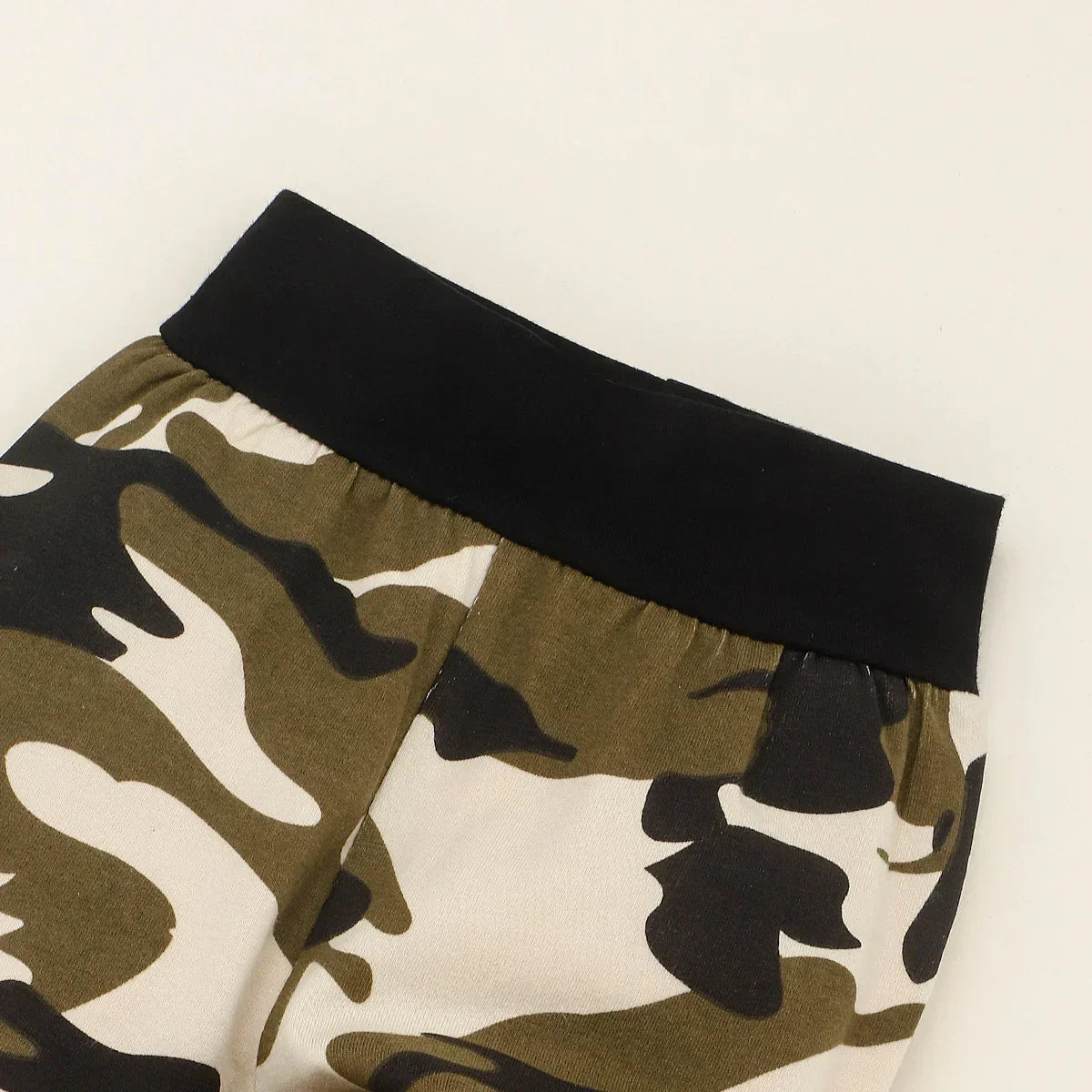Close-up of camo print jogger pants with black elastic waistband, soft cotton blend fabric