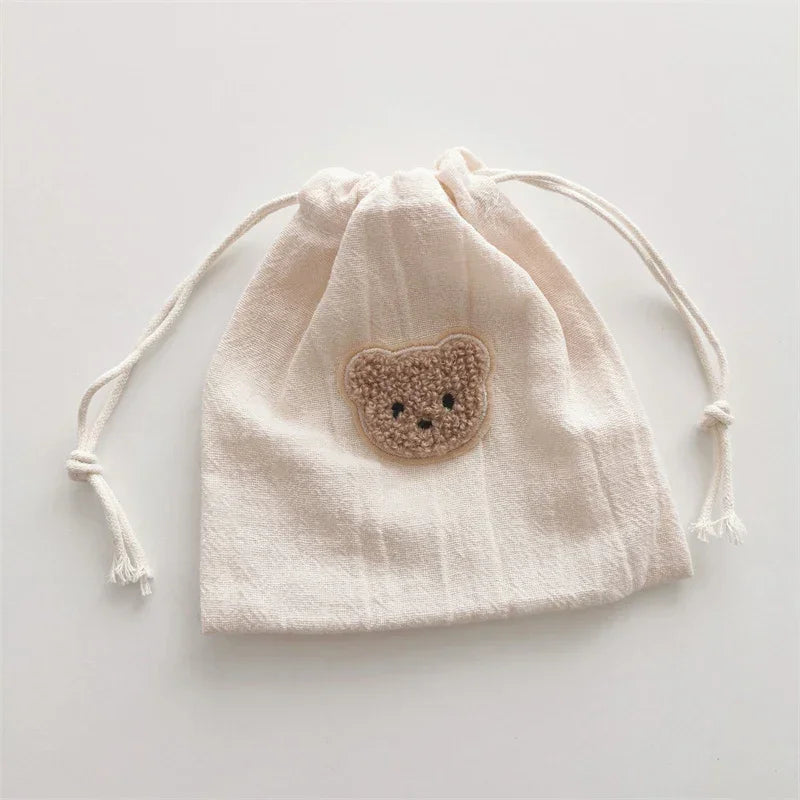 Beige cotton drawstring pouch with cute bear patch, soft texture, casual minimalist style