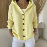 Light yellow knit hooded cardigan with brown buttons, relaxed fit, styled with white pants