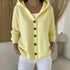 Light yellow knit hooded cardigan with brown buttons, relaxed fit, styled with white pants