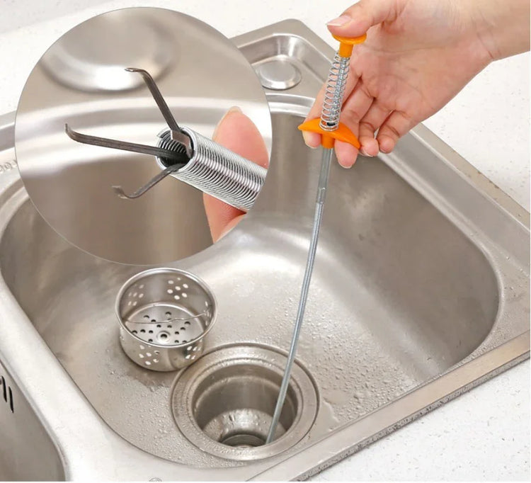 Flexible metal drain clog remover tool with spring and claw in use in a kitchen sink