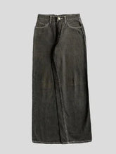 Wide-leg black denim jeans with contrast stitching and relaxed fit on grey background
