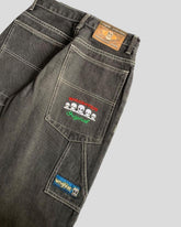 Black denim jeans with white stitching, relaxed fit, featuring alien-themed embroidery on the back pockets