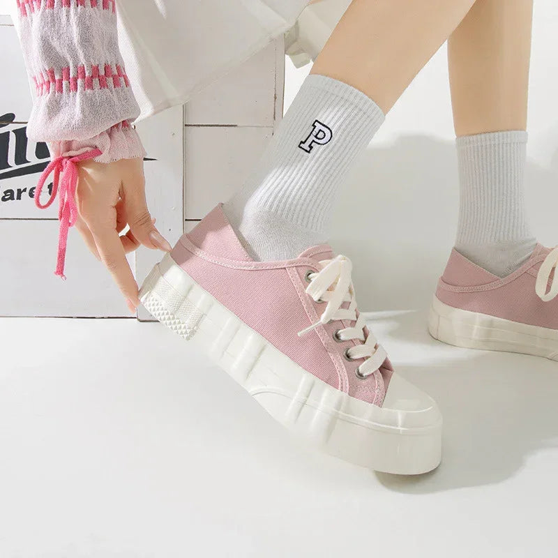 Pink canvas platform sneakers with thick white soles, paired with white ribbed socks