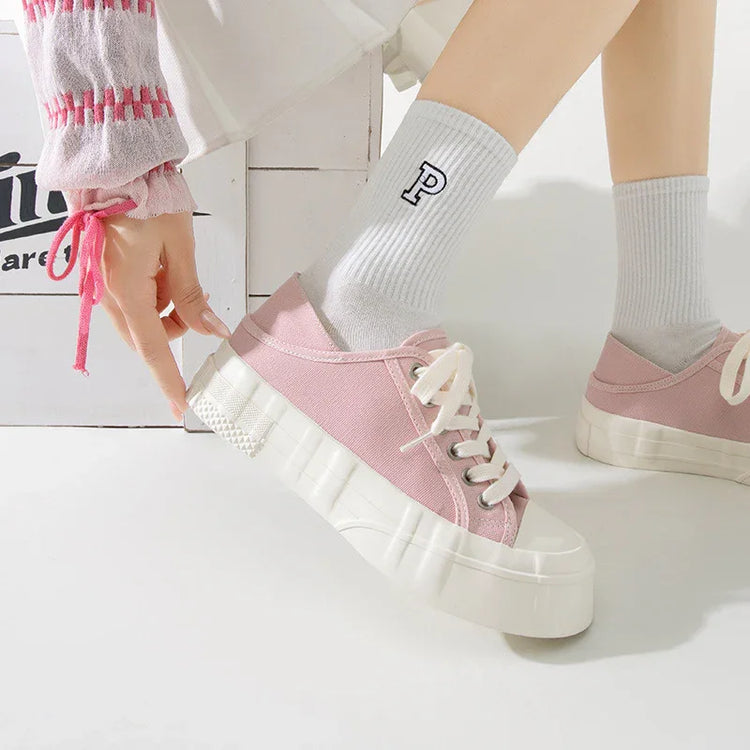 Pink canvas platform sneakers with thick white soles, paired with white ribbed socks