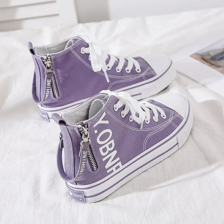 Purple canvas high-top sneakers with white laces, side zippers, and bold lettering, casual fit.