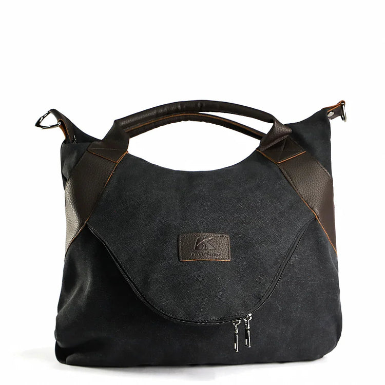 Black canvas shoulder bag with brown leather accents and front zip pocket, casual fit