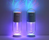 Two capsule-shaped humidifiers with clear containers and colorful LED lights in a dark room