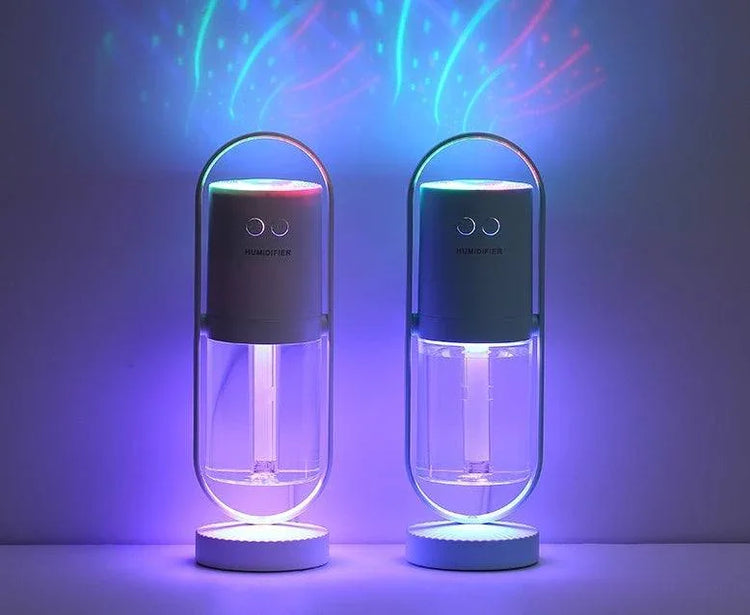 Two capsule-shaped humidifiers with clear containers and colorful LED lights in a dark room